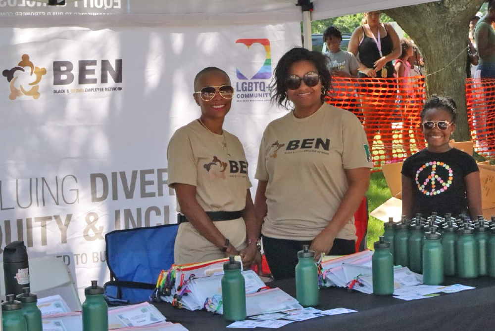 Figure 1: BEN leaders Alicia Brooks and Shayla Deering stand with items for students' backpacks at the 2024 Back 2 School Bash. 